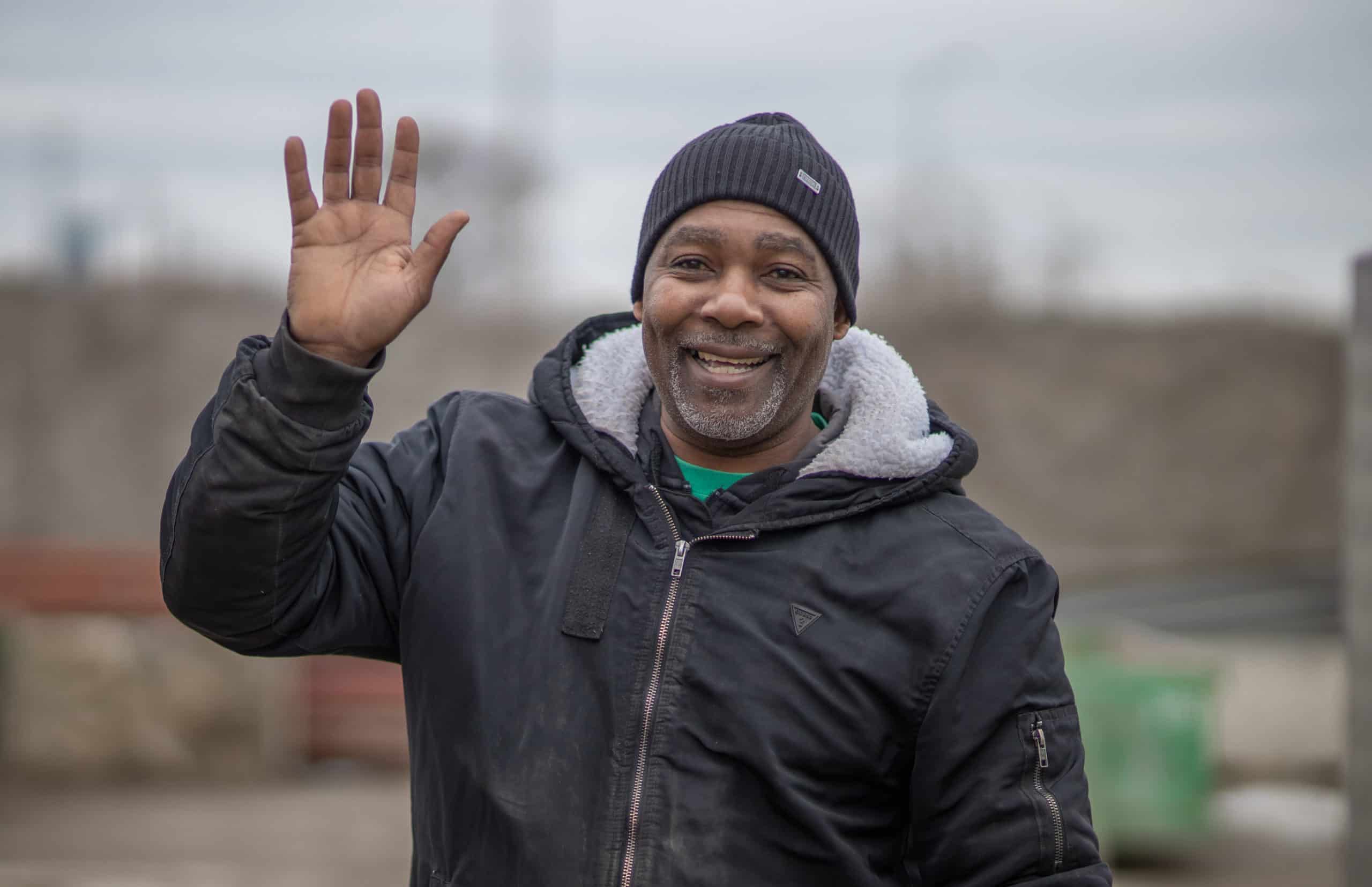 Man smiling and waving